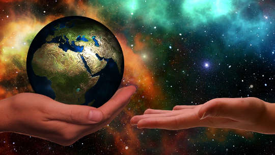 one hand holding the planet, the other open ready to receive it