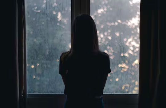 silhouette Of A Woman Standing In Front Of A Window