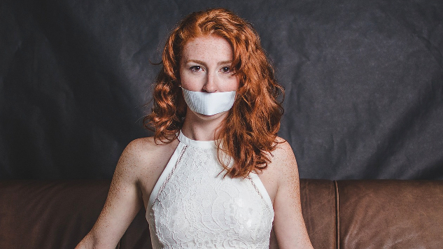 woman in evening gown silenced with tape on her mouth