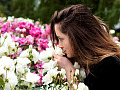 a woman smelling a bush of roses